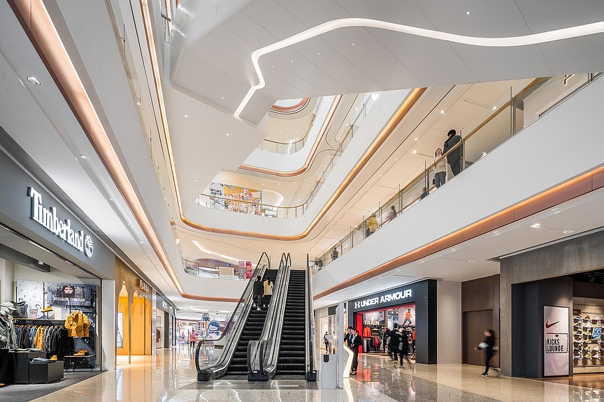 A large white and yellow building with people walking around.